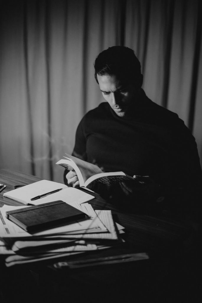 focused man reading diary in home office